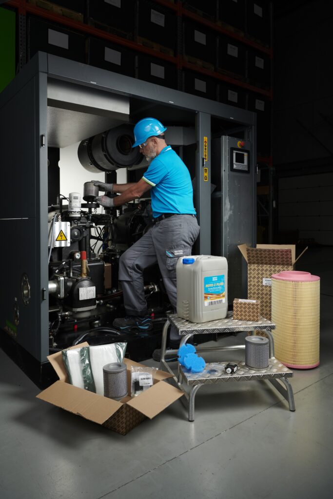 Male service technician servicing an Oil Free screw machine with a service kit